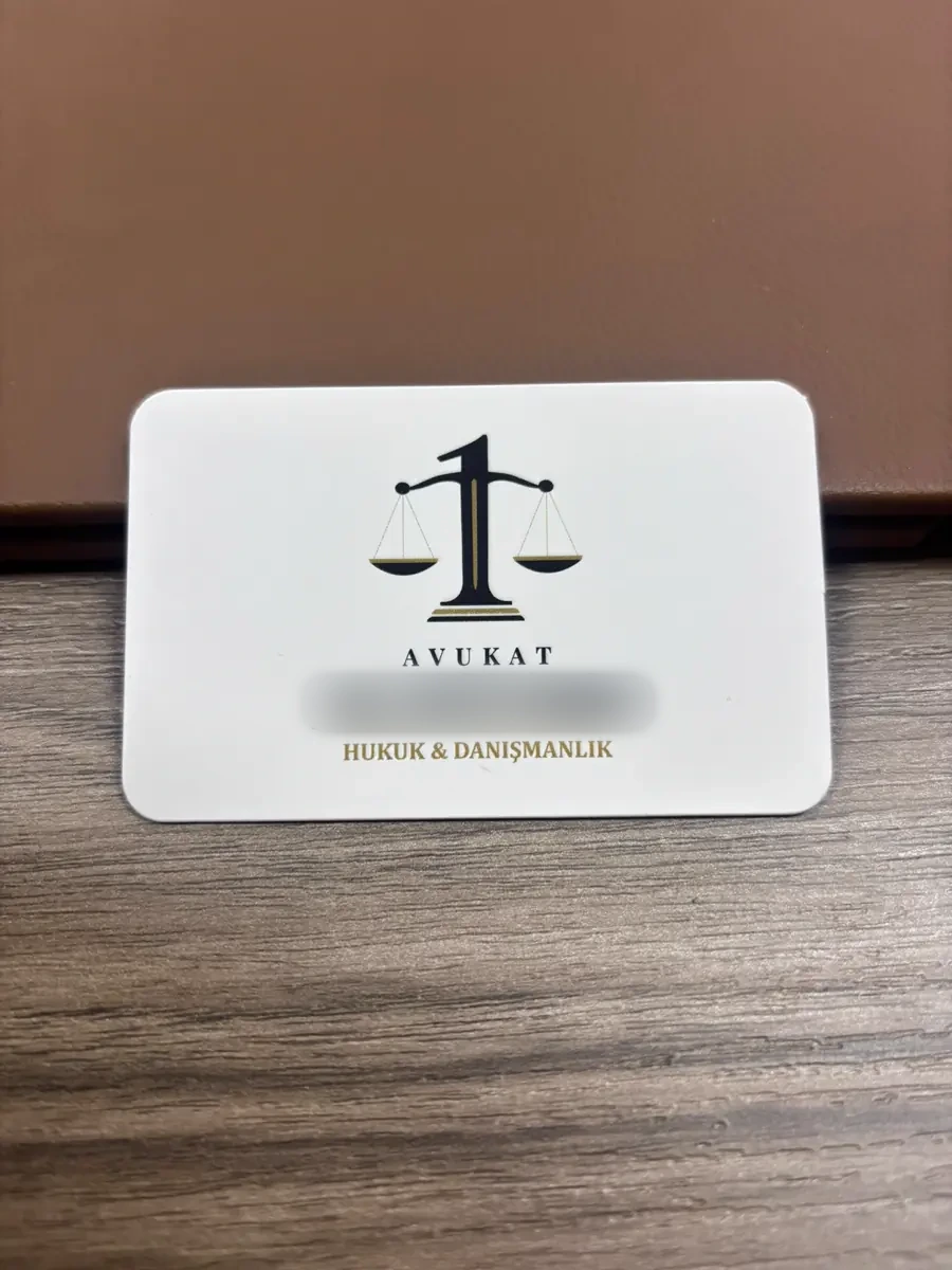 Av. A. B. kartvizitinin basılı hâli, ahşap masa üzerinde ön yüz, Av. A. B., Kemalpaşa / İzmir
