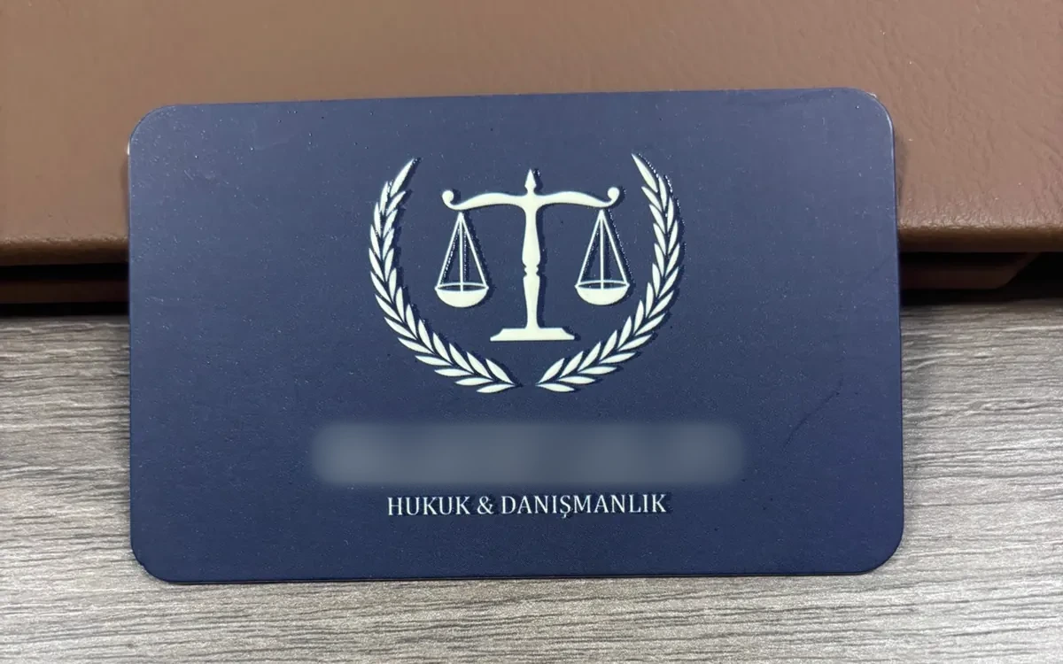 Av. İ. A. kartvizitinin basılı hâli, lacivert zemin üzerine krem terazi ve defne dalı