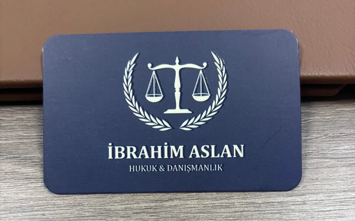 Av. İbrahim Aslan kartvizitinin basılı hâli, lacivert zemin üzerine krem terazi ve defne dalı